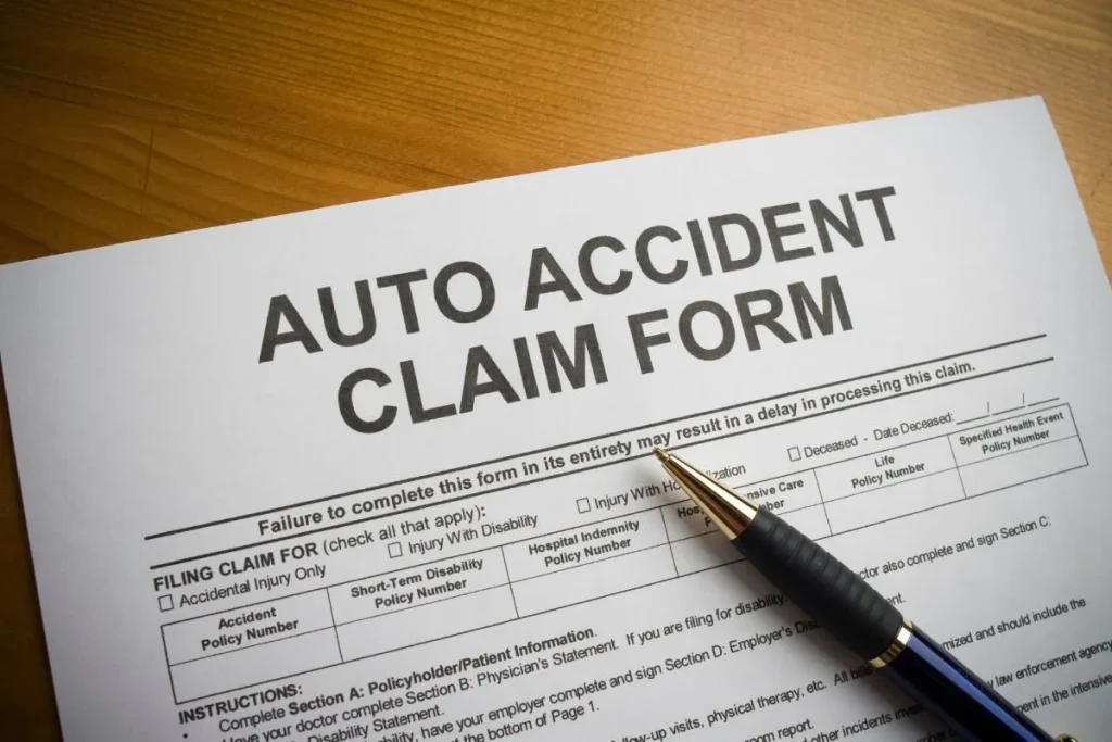 Auto accident insurance claim form and pen on a desk for non-fault claims filing
