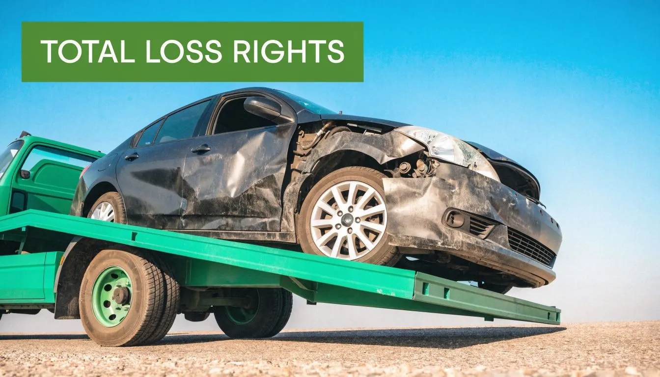 A severely damaged car loaded on a tow truck bed representing a total loss vehicle accident.